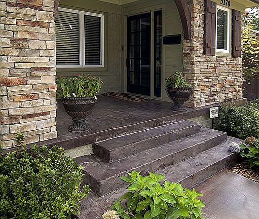 Large covered front porch w/ dry-stack entry and stamped concrete.