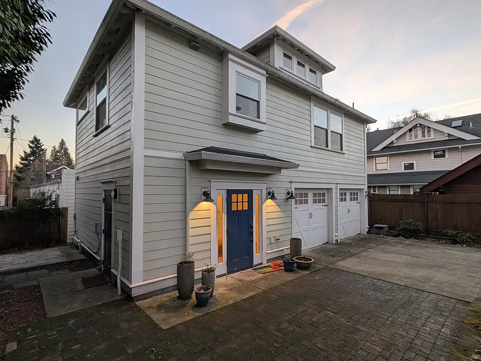 Front and side entries to carriage house and garage/storage. (Left garage bay included with unit.)