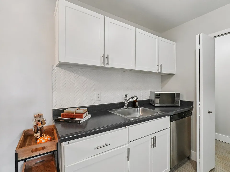 Enjoy stylish kitchens with bright white cabinetry and sleek dark countertops, professionally operated by Highlands Vista Group.