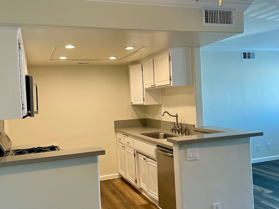 Kitchen w/quartz counters, large sink, and stainless appliances.