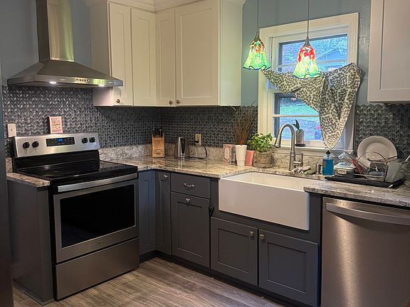 Renovated kitchen with farmhouse sink and granite countertops