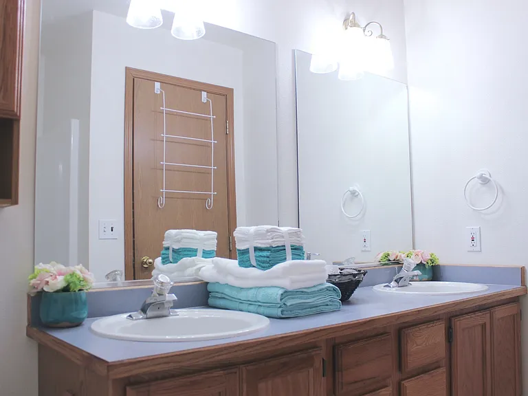 Full bathroom with double sinks, tub, and shower on main floor