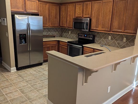 Kitchen with tile floors and backsplash and corian countertops