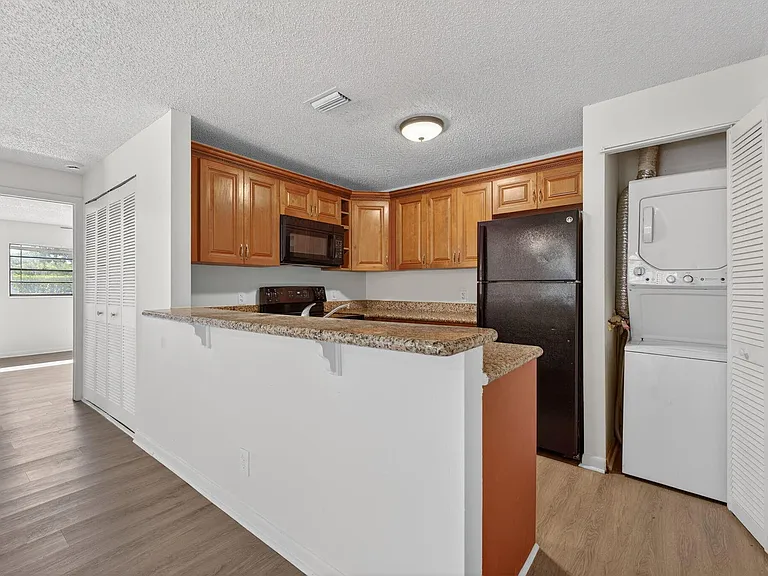 Open kitchen with bar top and an in-unit Washer/Dryer.