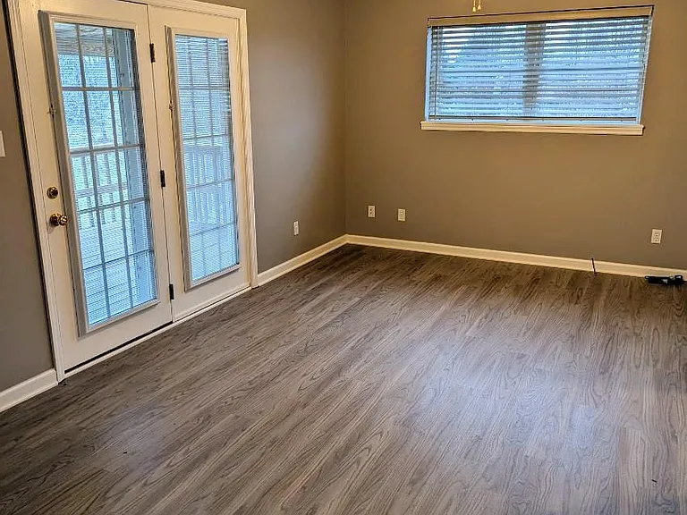 living area with french doors leading to the covered balcony