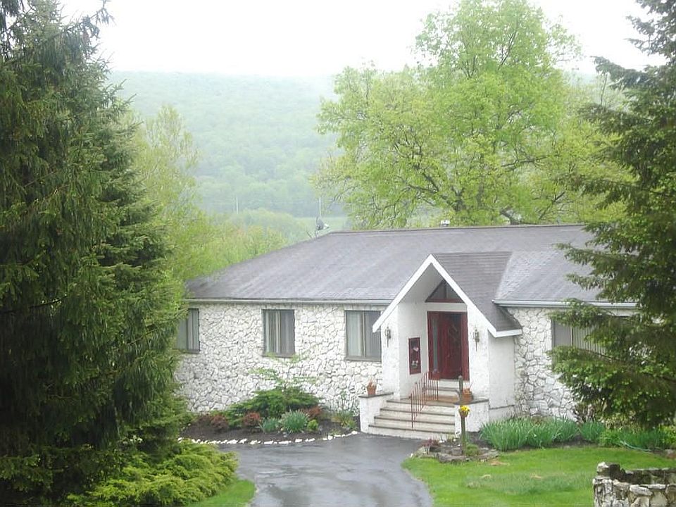 Sits back from the road, a circular driveway surrounded by mature landsacaping