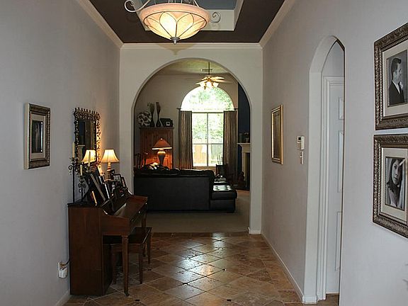 Large foyer with travertine tile and granite inserts, designer paint touches and updated light fixtures.
