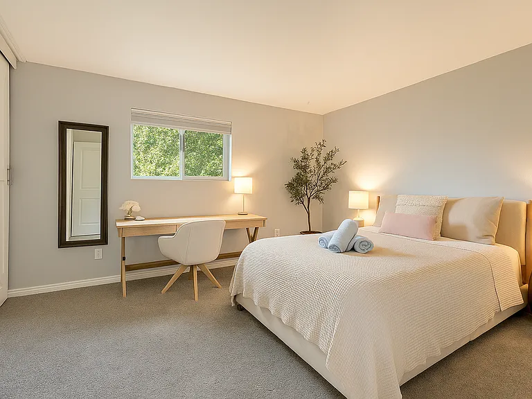 The soft, neutral tones and cozy textures invite rest and relaxation, while the thoughtfully placed workspace offers a quiet spot to journal, catch up on work, or enjoy a slow morning coffee.