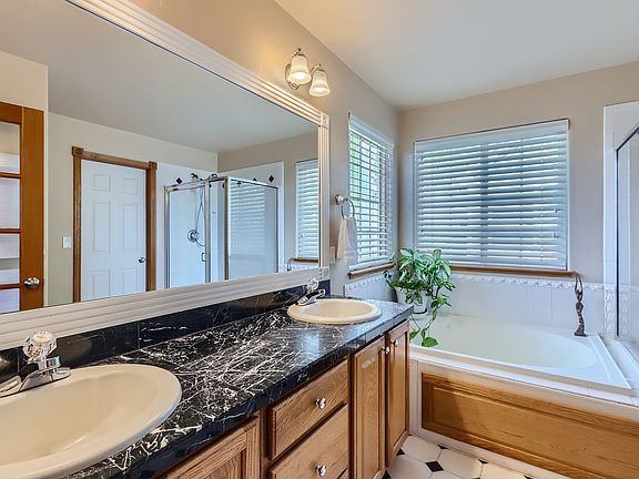 Upper Level Primary Suite 5-piece bathroom with dual sinks, jetted tub, shower, toilet and walk-in closet.