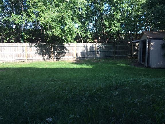 Large fenced in back yard with shed