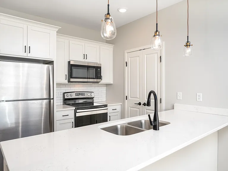 Modern kitchen design with sleek stainless steel appliances, elegant white cabinetry, and stylish pendant lighting. Modern kitchen design with sleek stainless steel appliances, elegant white cabinetry, and stylish pendant lighting.