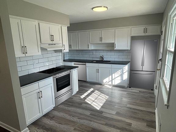 Brand new kitchen with stainless appliances opens to the living room