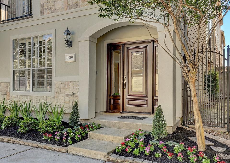 Front Elevation: Freshly painted stucco accented by stone and a three unit mahogany front door, Pebbled side yard behind wrought iron gate