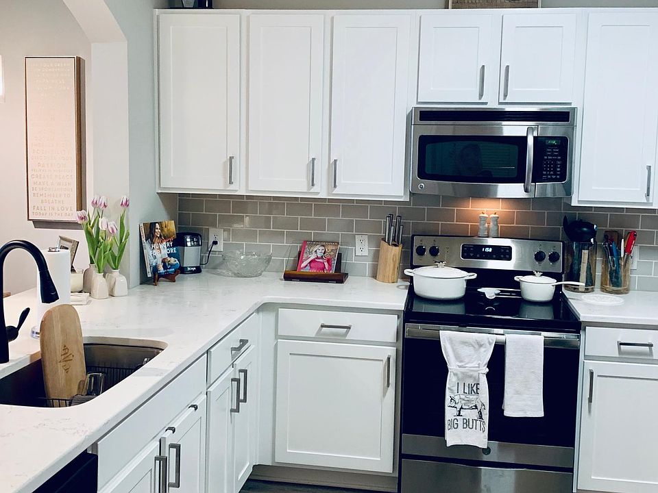 All-white updated kitchen with stainless steel appliances
