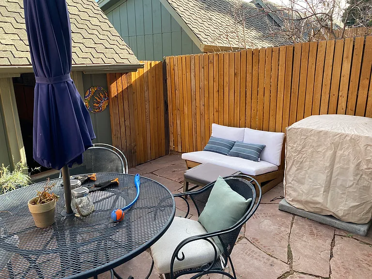 patio table and chairs and small couch with ottoman. AC unit is next to small couch.