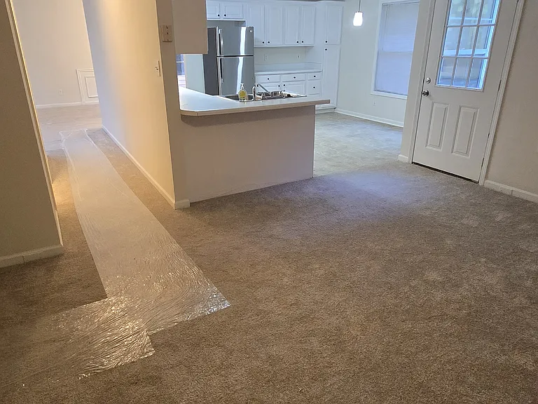 Den looking to the kitchen and hallway to the living area