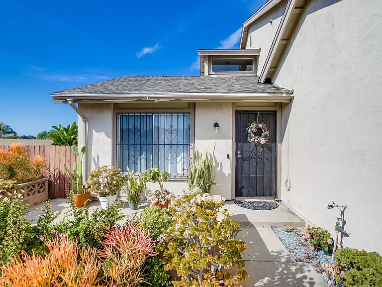 A vibrant front yard welcomes you to this luxurious, modern home
