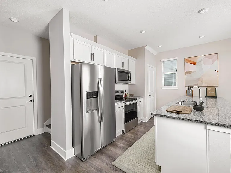 A bright, streamlined kitchen at Amavi Kissimmee features stainless steel appliances and generous counter space, creating a clean, inviting place to start and end each day.