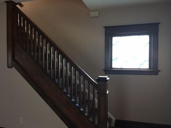 Stairs going upstairs w/stained glass window