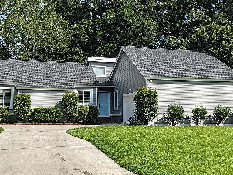 two car attached garage with additional parking pad to the left of the home