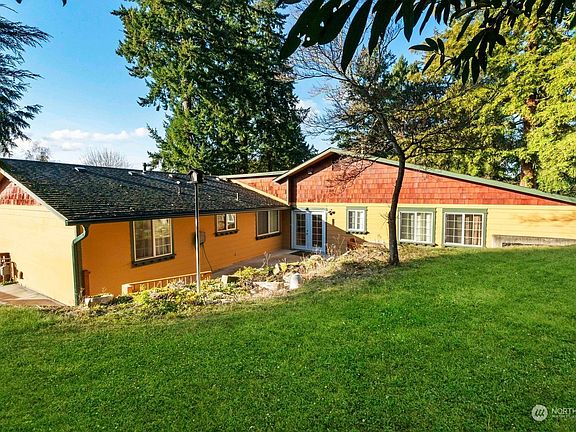 Large partially fenced .33-acre property that has a private feel.  This view shows the back patio and yard.>