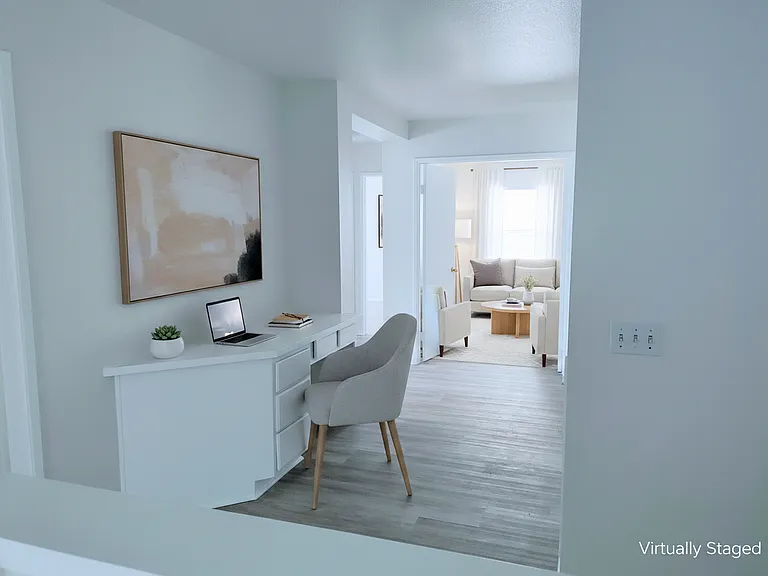 Upstairs hallway with view into primary bedroom, virtually staged