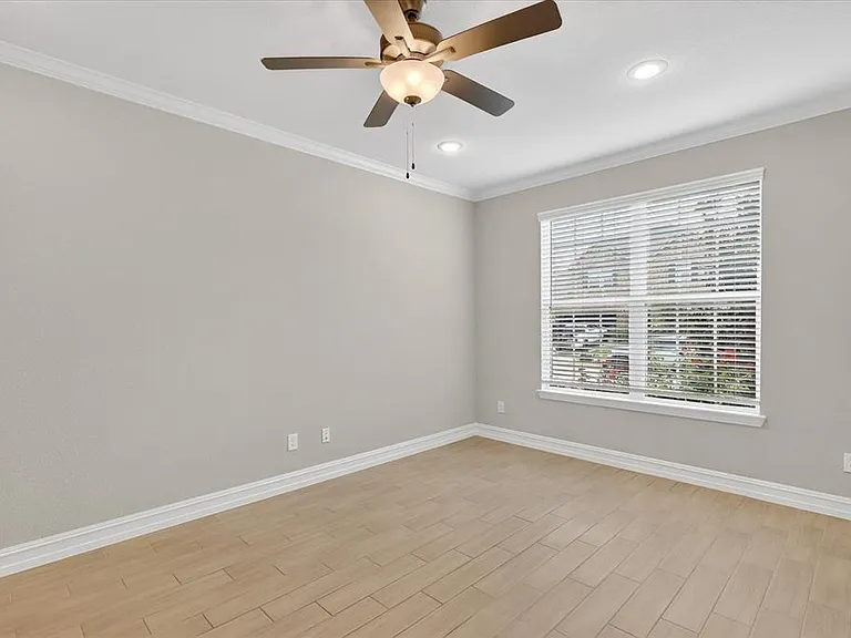 Neutral-toned room with wood-finish tile flooring and crown molding