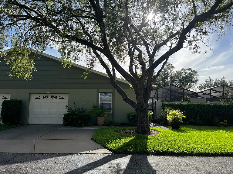 Front of Villa with weekly HOA maintained lawn and tree.