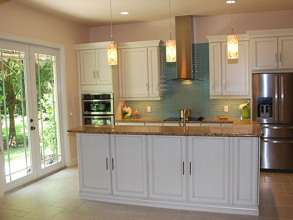 Kitchen 1 : Island has cabinets and countertop design for barstools.