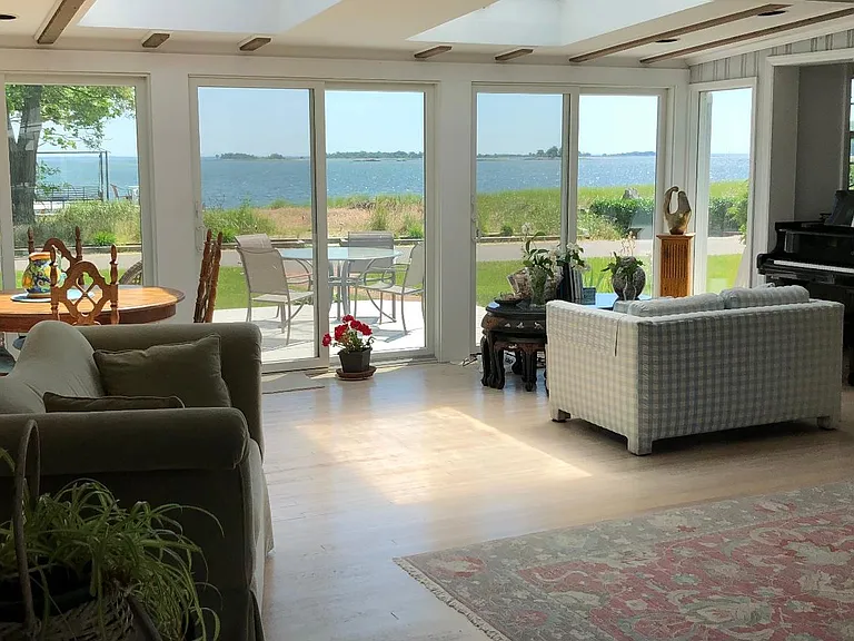 Panoramic water views from the great room with deck right outside the sliding doors and flooded light from skylights above