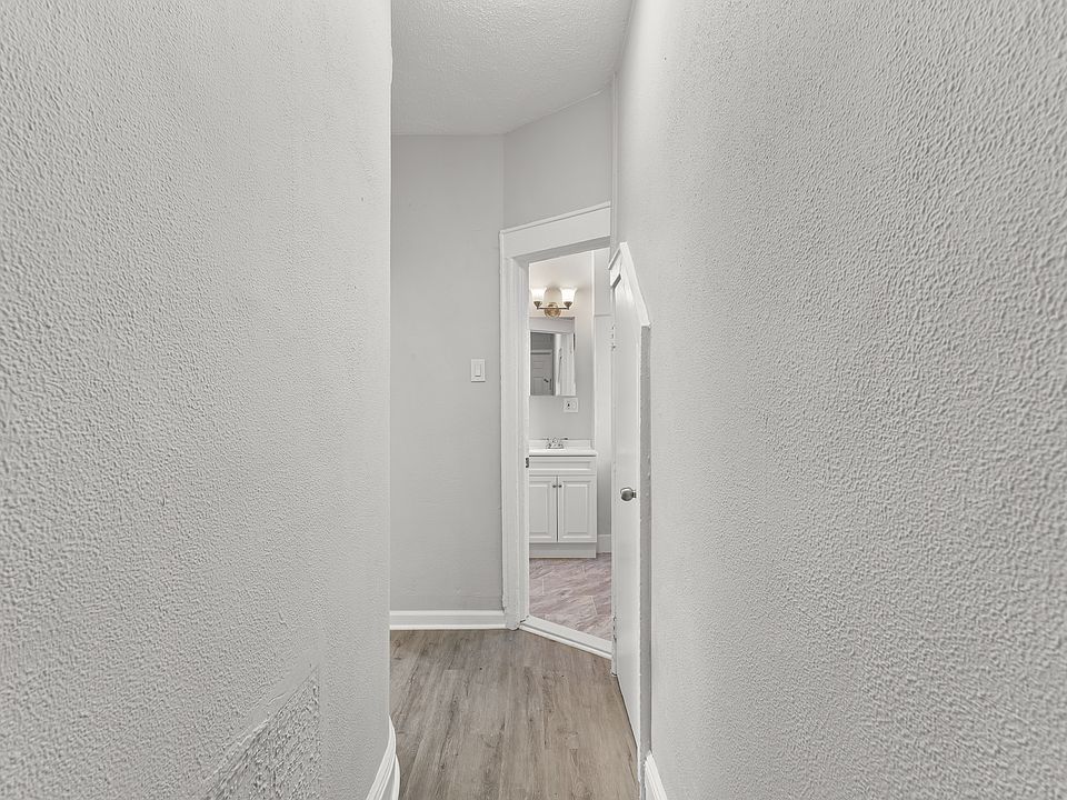 Bright hallway with modern flooring and neutral finishes, offering a clean, seamless flow between rooms. Sleek design enhances the open feel and connects living spaces effortlessly.