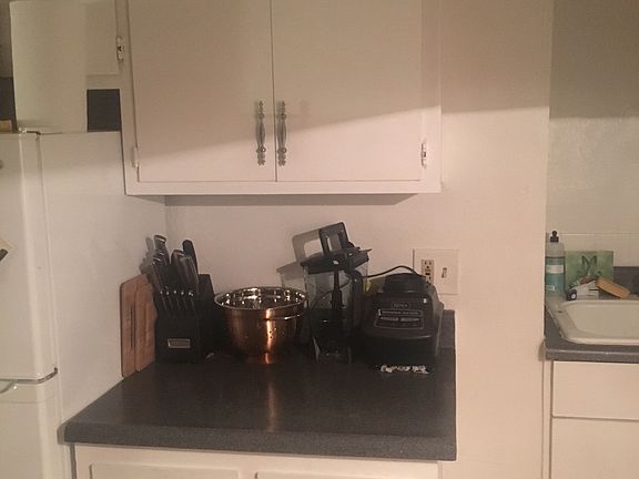 Counter in kitchen between refrigerator and sink