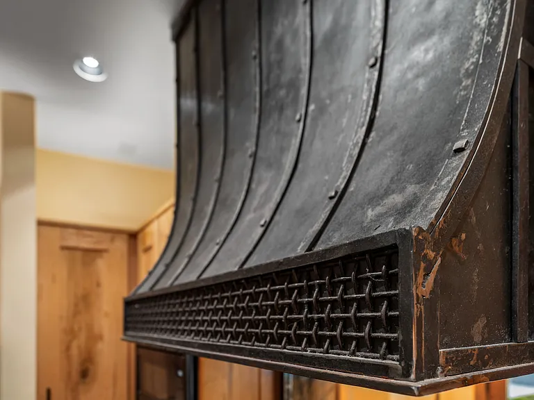 Artisan blacksmith hand hammered this custom kitchen range hood.