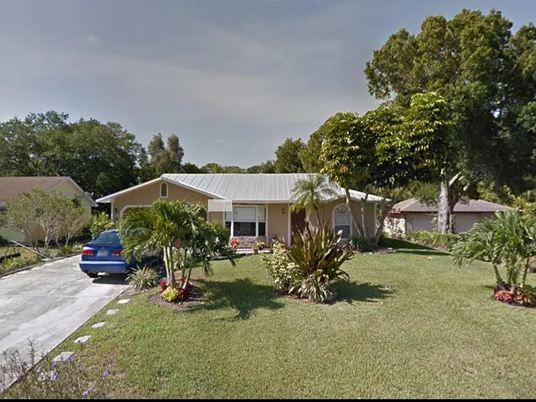 Single-story home with a long driveway, mature landscaping, and a spacious front yard for outdoor enjoyment.