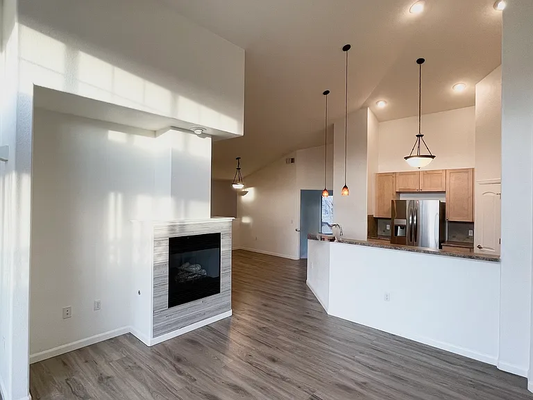 Living room, dining and kitchen, with entrance to primary bedroom visible, All have access to large deck.