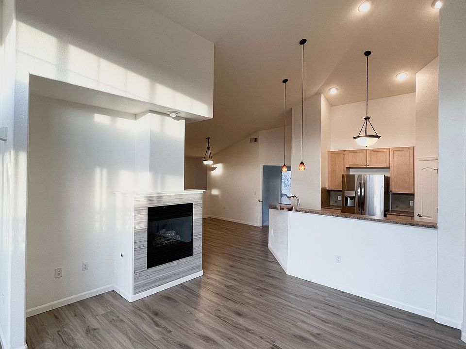 Living room, dining and kitchen, with entrance to primary bedroom visible, All have access to large deck.