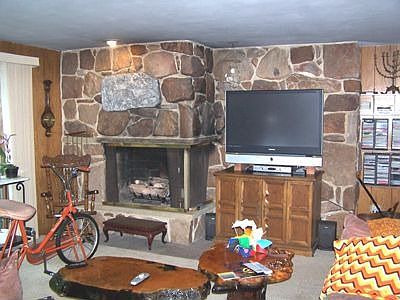 A stone fireplace is the focal point of the family room. Sliding doors open directly to a second patio.