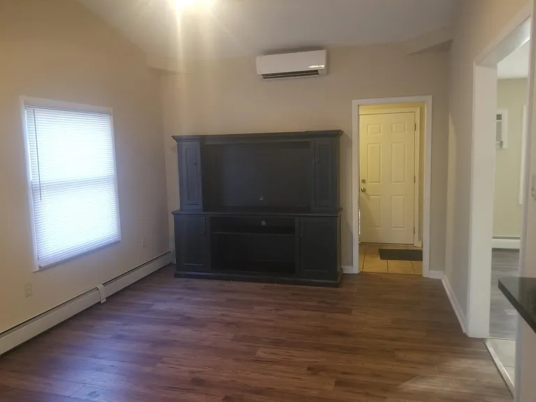 Den with view of back door mud/laundry room