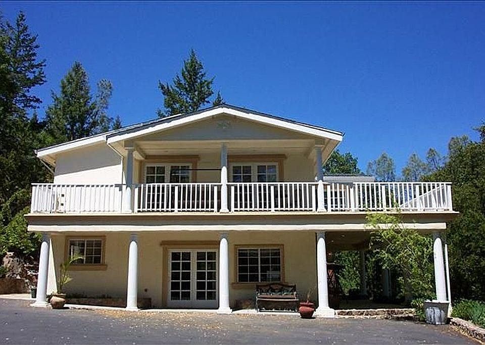 Lower sliding door is entrance to studio apartment. To the right is a porch. Upper level shows sliding doors of 2 of 3 bedrooms.