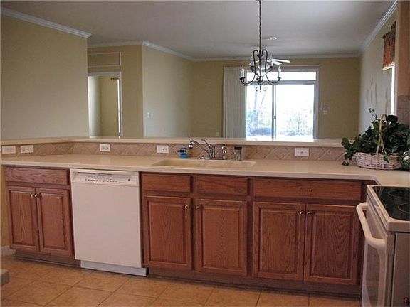 KITCHEN HAS CUSTOM COUNTERS AND STONE BACK SPLASH. SLIDE OUT SHELVES GIVE GREAT STORAGE.