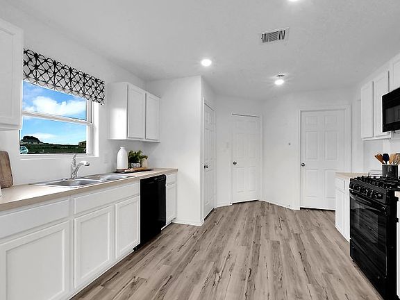 The spacious kitchen boasts a complete set of brand-new appliances and stylish flooring. An ample su