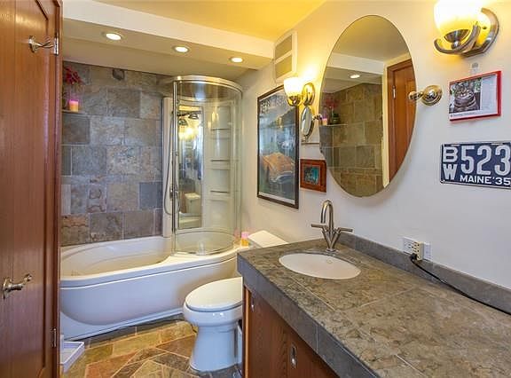 Large bathroom has two African Mahogany doors-one to kitchen for guest use and one leading to bedroom. Large Jacuzzi brand tub with jet and standing shower.