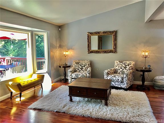 Lovely entrance into your vaulted living room with view of the front deck and gorgeous mature landscape!