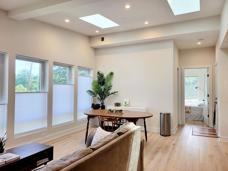 Living room with 12-ft ceiling and skylights. Front bedroom in the background.
