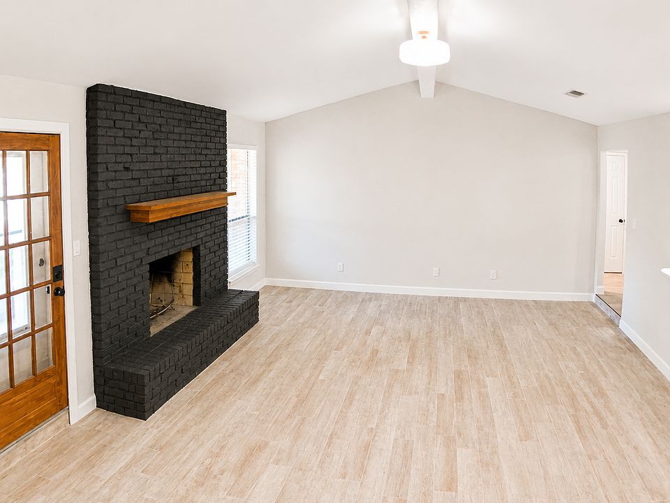 Living Room with vaulted ceiling - open to kitchen, door to back yard covered patio