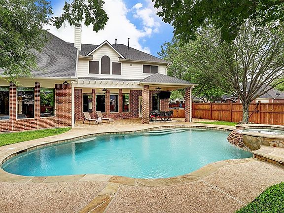 View of the pool waterfall, spa, backyard arbor and covered patio and on a corner lot so there is much more privacy on the side.