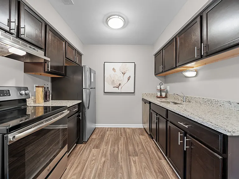 Spacious Kitchen with stainless steel appliances and dark cabinets at Lakeside Village Apartments Clinton Township, MI