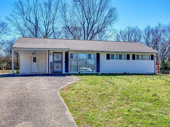 Ranch home with carport and large yard.
