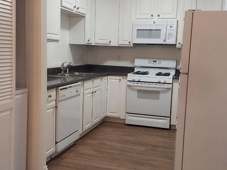 Full-Size Kitchen with Ample Cabinet Storage and Vinyl Flooring