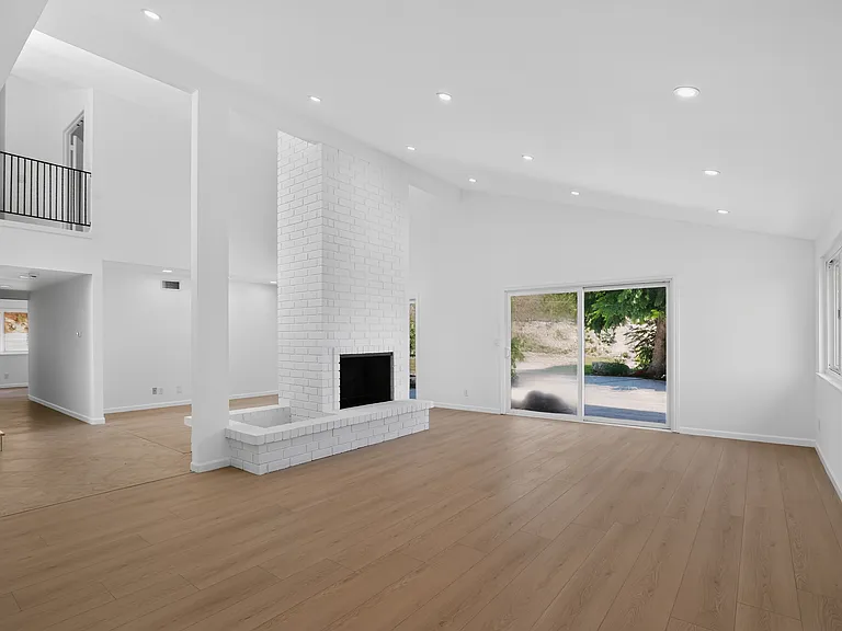 Living room with dining room behind fireplace.